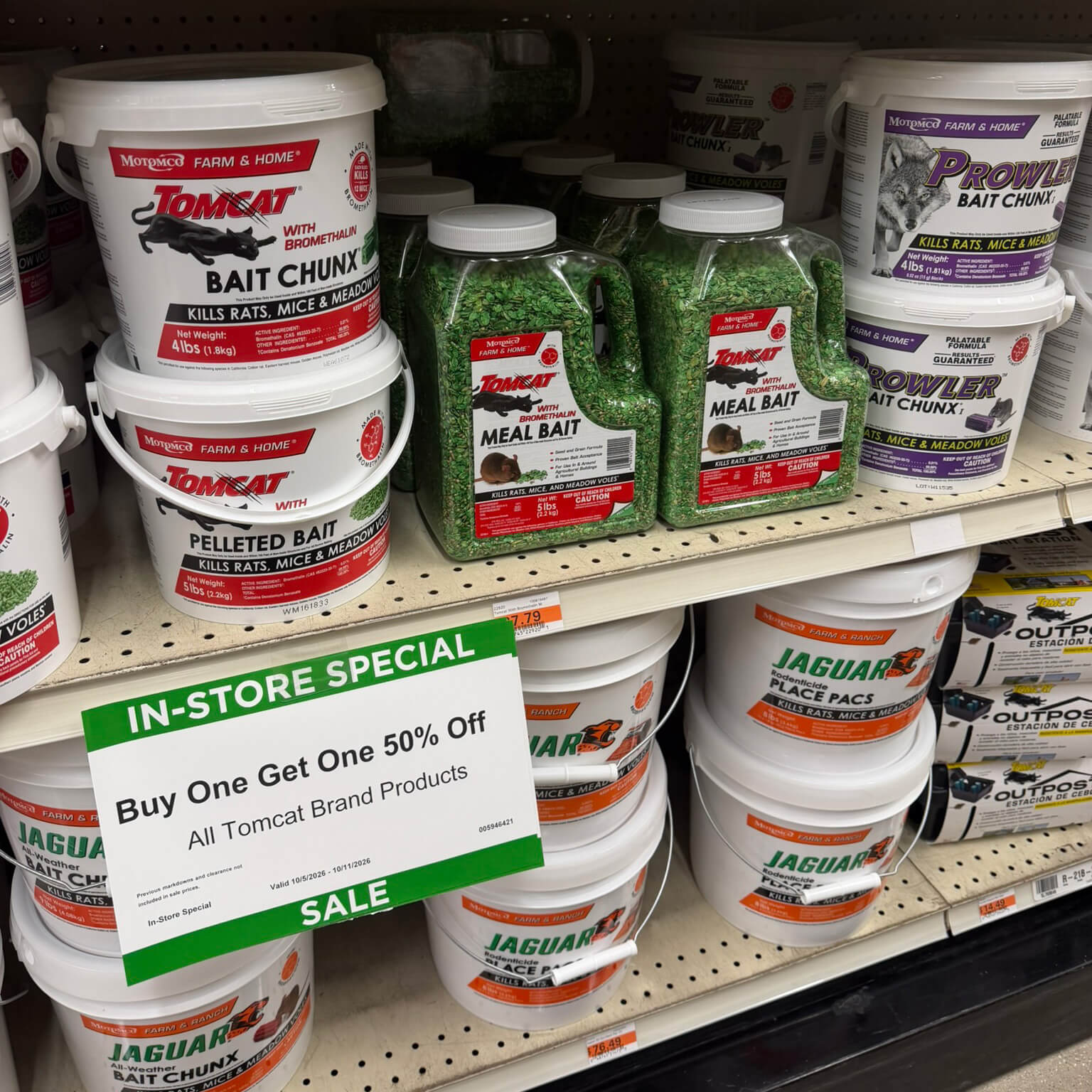 Tomcat and Jaguar rodent bait pails and jugs with pressure-sensitive labels on a farm and home store shelf