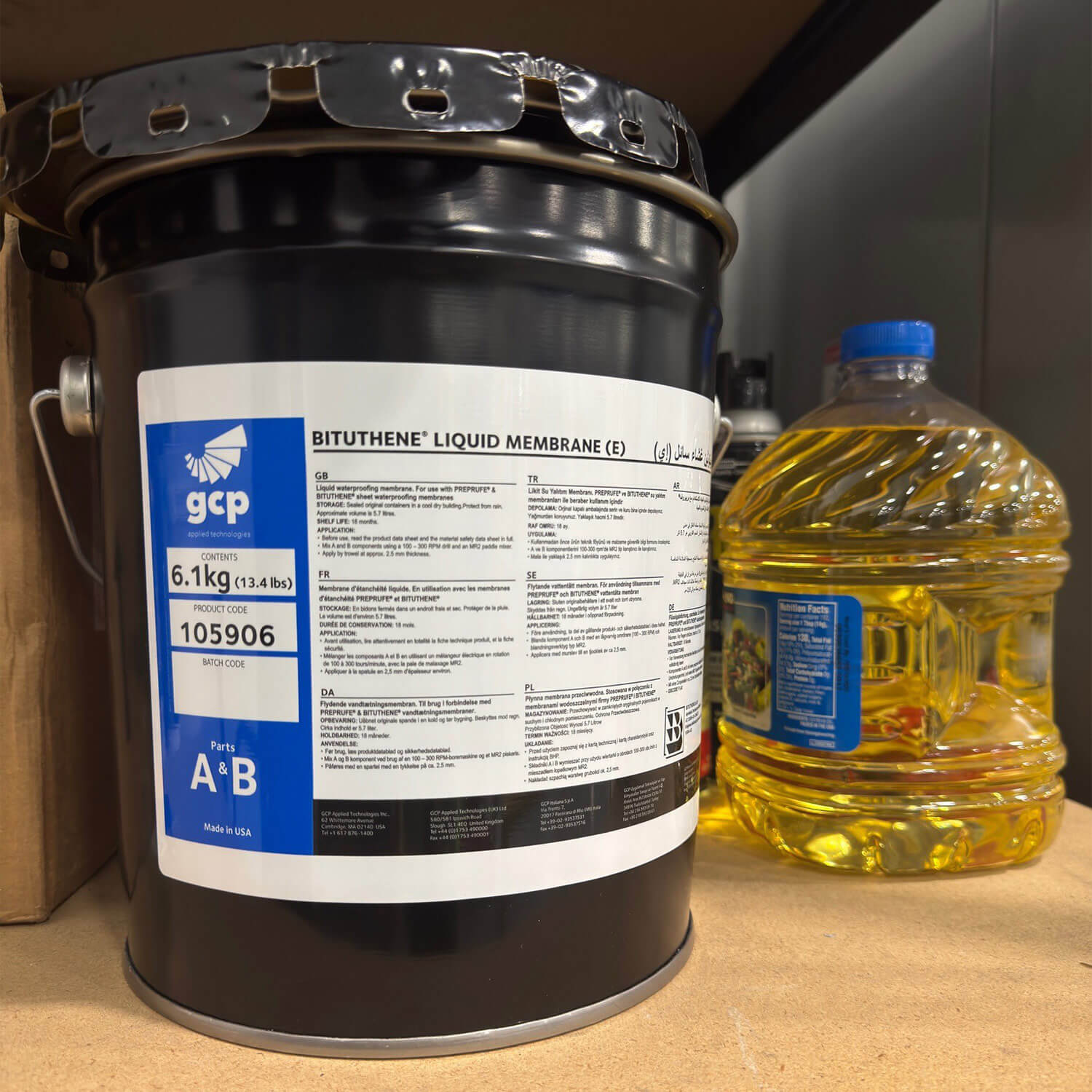 Black steel pail of GCP Bituthene Liquid Membrane with a multilingual wraparound label