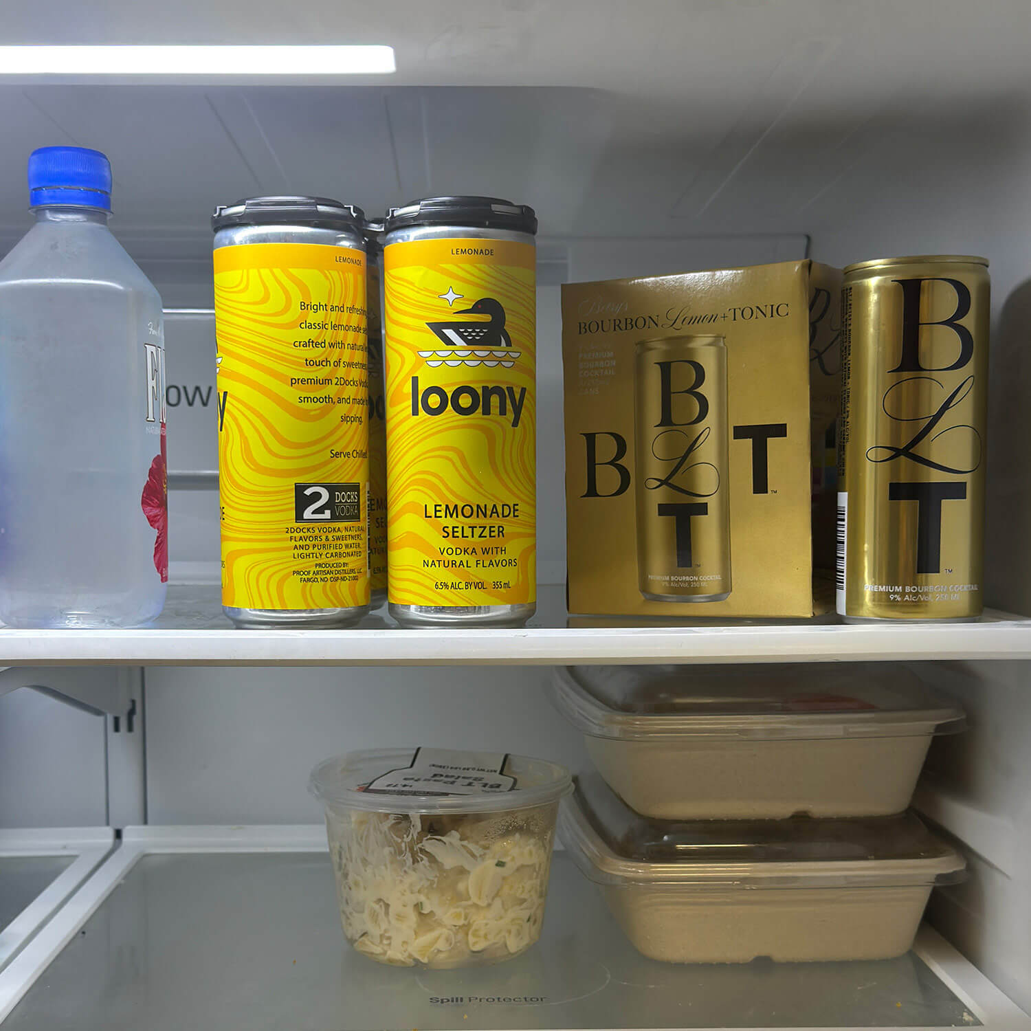 Loony lemonade seltzer cans with full-body shrink sleeves on a refrigerator shelf