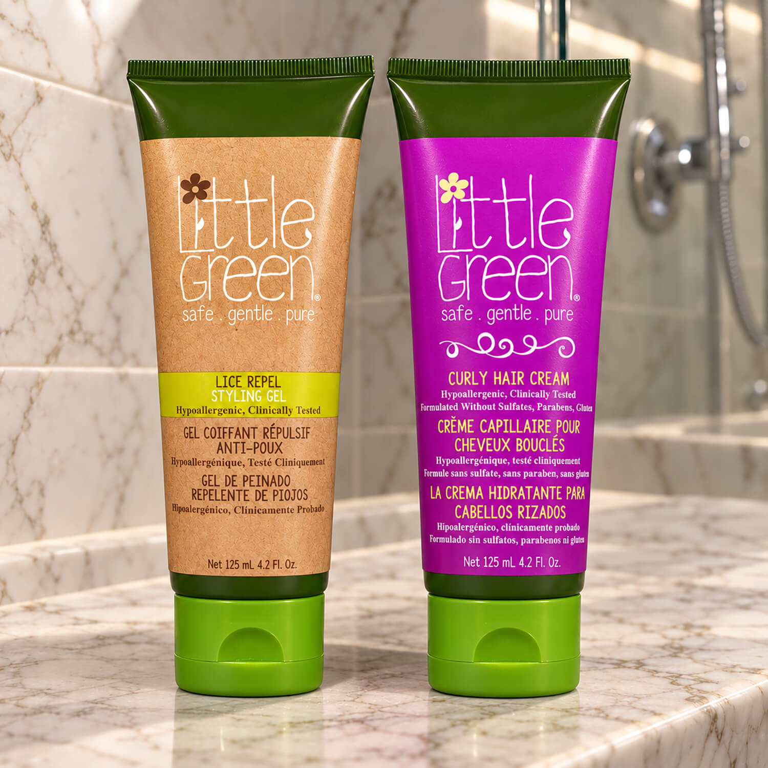 Two Little Green hair care tubes with full-color labels on a marble shower ledge